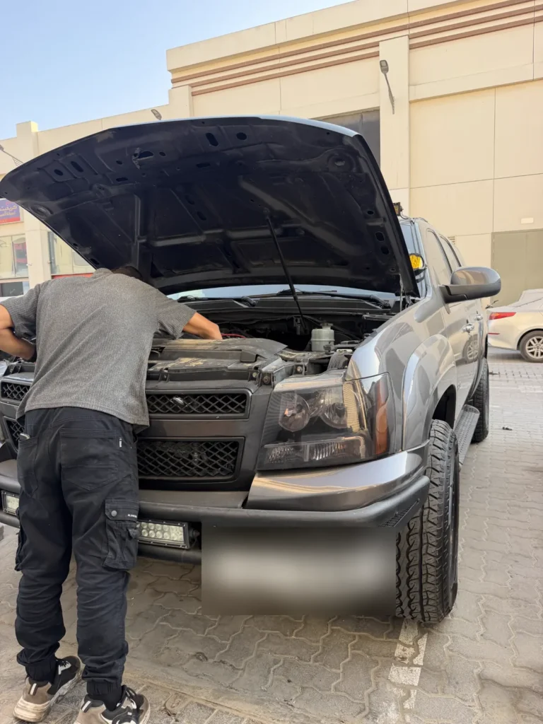 فني يفحص محرك سيارة في موقعها